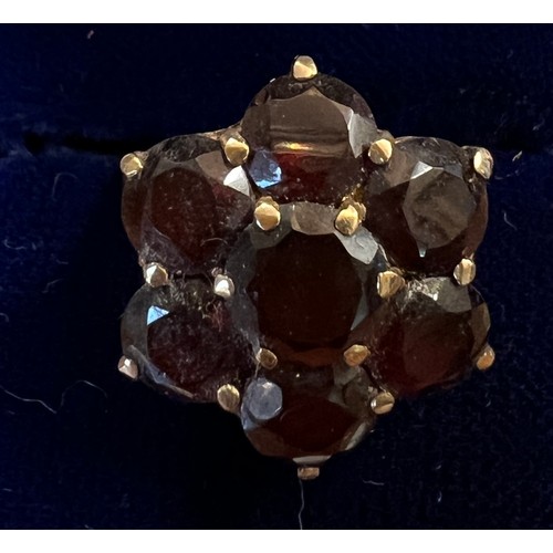 478 - A 9 carat gold cluster ring set with dark red stones. Size N. Weight 4.2gm.