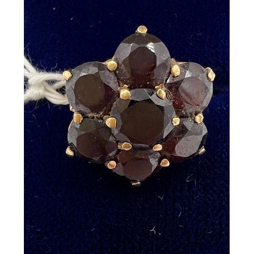 478 - A 9 carat gold cluster ring set with dark red stones. Size N. Weight 4.2gm.