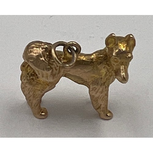 490 - A 9 carat dog charm on a 9 carat gold suspension ring. Weight 7.3gm.