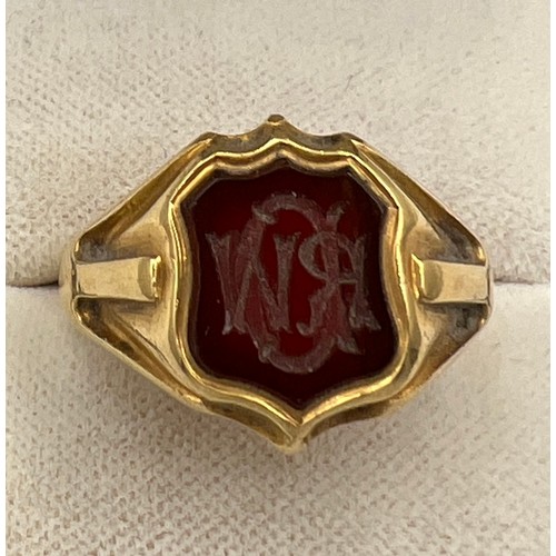 497 - An 18 carat gold signet ring with onyx initialled seal to the front. Weight 11.8gm. Inscribed inside... 