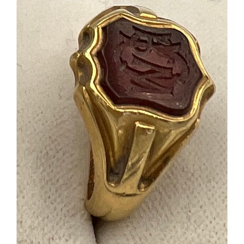 497 - An 18 carat gold signet ring with onyx initialled seal to the front. Weight 11.8gm. Inscribed inside... 