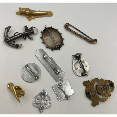 498 - Badges and brooches to include 9 carat bar brooch, silver Holbeach brooch, white metal and onyx anch... 