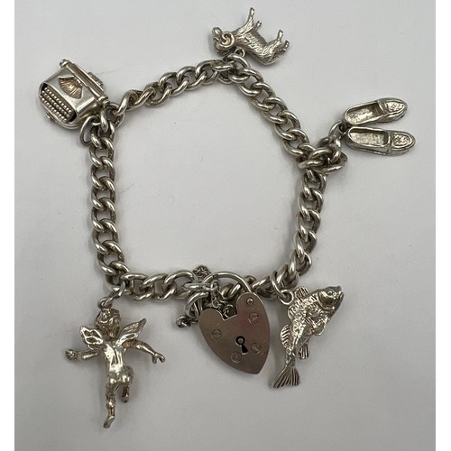 499 - Silver charm bracelet with five charms. Weight 30.5gm.