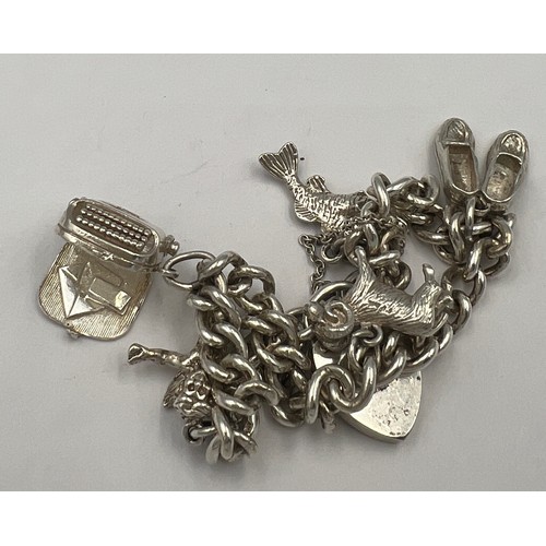 499 - Silver charm bracelet with five charms. Weight 30.5gm.