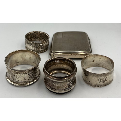 733 - Four silver napkin rings and a silver cigarette case. Various dates and makers. Total weight 158gm.