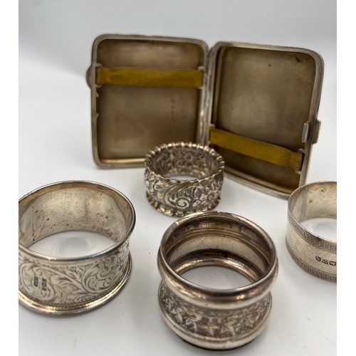 733 - Four silver napkin rings and a silver cigarette case. Various dates and makers. Total weight 158gm.