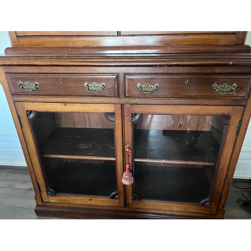 110 - A double height mahogany display/bookcase. Two glazed doors to top with mirrored roundels and corner... 