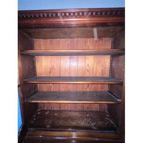 110 - A double height mahogany display/bookcase. Two glazed doors to top with mirrored roundels and corner... 