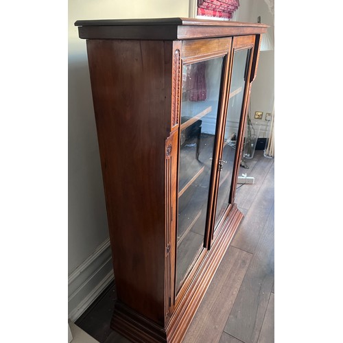 113 - A mahogany floor standing bookcase with two glazed doors and 4 adjustable interior shelves. 118 w x ... 