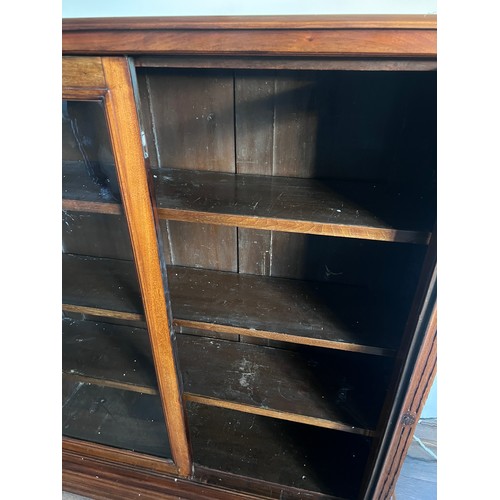 113 - A mahogany floor standing bookcase with two glazed doors and 4 adjustable interior shelves. 118 w x ... 