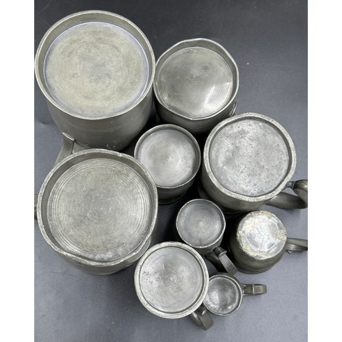 912 - Eight old pewter tankards, various sizes, tallest 17.5cm and smallest 7cm together with a pewter cup... 