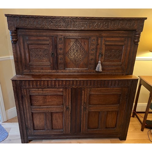 45 - An oak court cupboard with carving to the top, MA 1698. 138cm w x 57cm d x 151cm h.
Top shows signif... 