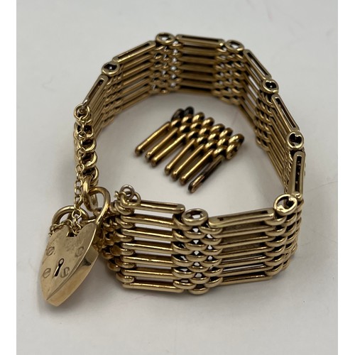 444 - A 9 carat gold gate bracelet with extra link and heart shaped padlock with safety chain. Total weigh... 