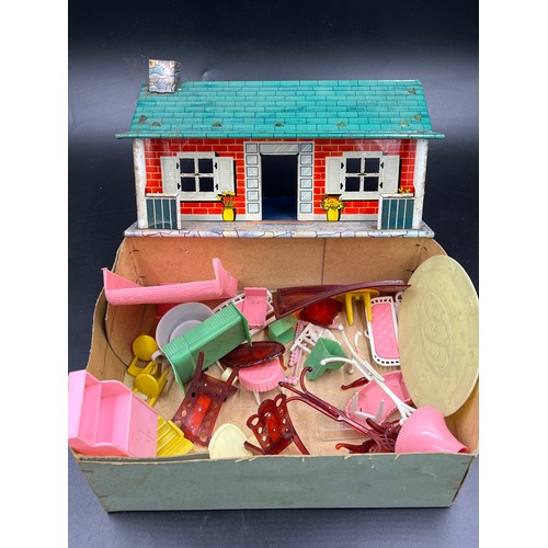 814 - A vintage tin plate dolls house, 28cm l x 18cm w x 13cm h. and various plastic dolls house furniture... 