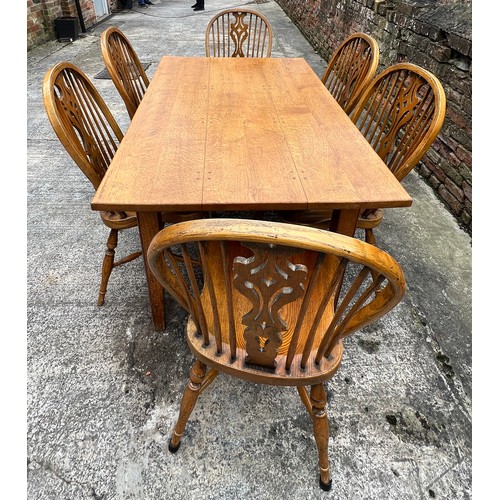 24 - A good quality oak table and set of six windsor style dining chairs with crinoline stretchers. Table... 