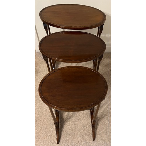 38 - An Edwardian nest of three mahogany oval topped tables. Largest 67cm h x 56cm w x 38cm d.