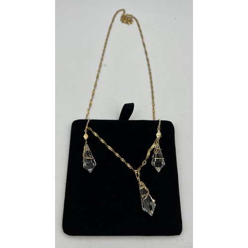 430 - A Uri Geller 9 carat gold and crystal earrings and matching necklace. In original presentation box. ... 