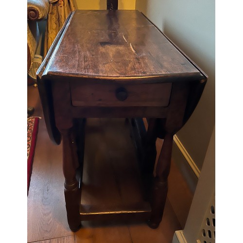 19 - A George I elm gate-leg table with drawer to one end. 102cm x 137cm open. 41cm closed.