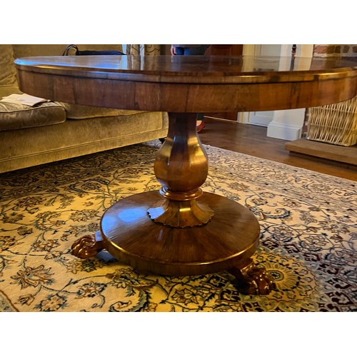 22 - A 19thC rosewood tip-top centre table with lions paw feet. 105cm d x 72cm h.