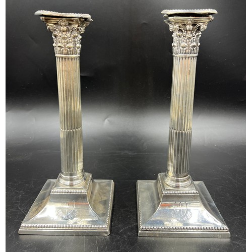 667 - A pair of Corinthian column silver candlesticks 28cm h. weighted bases. London 1884, Sheffield 1886,... 