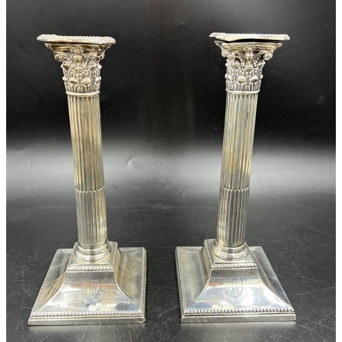 667 - A pair of Corinthian column silver candlesticks 28cm h. weighted bases. London 1884, Sheffield 1886,... 