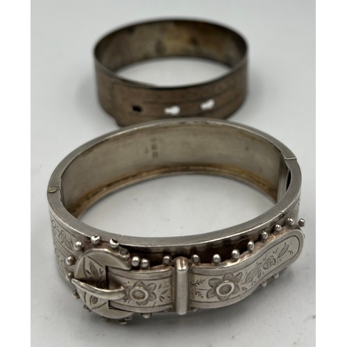 424 - A Victorian silver buckle bangle Birmingham 1885 together with an unmarked white metal bangle. Victo... 