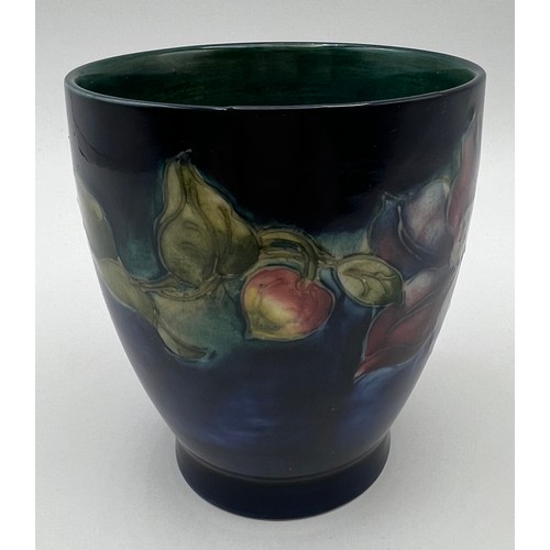 186 - A Moorcroft Hibiscus pattern vase on a blue ground. 9.5cm h.