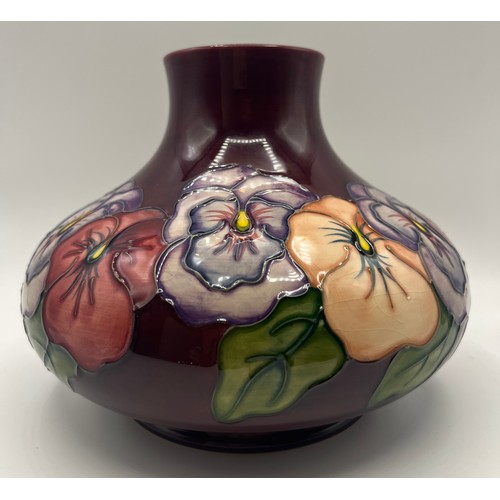 187 - A Moorcroft pan set pattern vase on a burgundy coloured ground, approximately 17cm h.