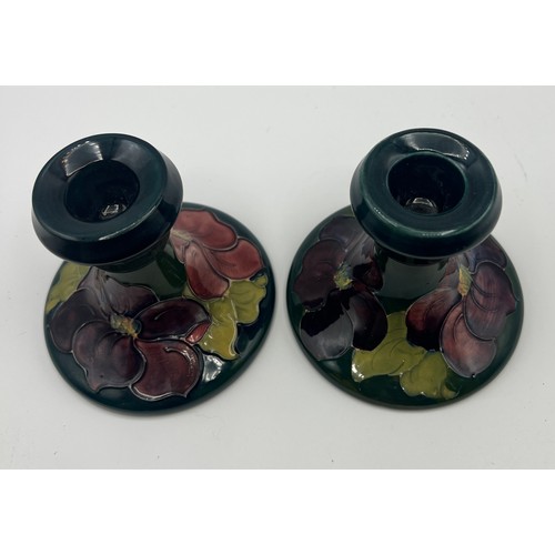 191 - A pair of Moorcroft Hibiscus pattern candlesticks. 9cm h.