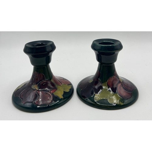 191 - A pair of Moorcroft Hibiscus pattern candlesticks. 9cm h.