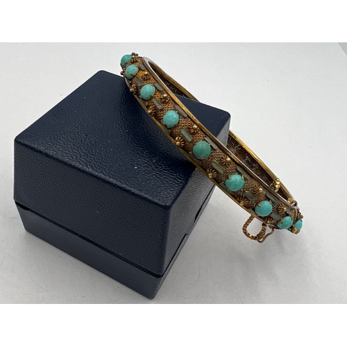 350 - A Chinese 14 carat yellow gold bangle set with turquoise and enamel. 7cm diameter. Weight 22.2gm.