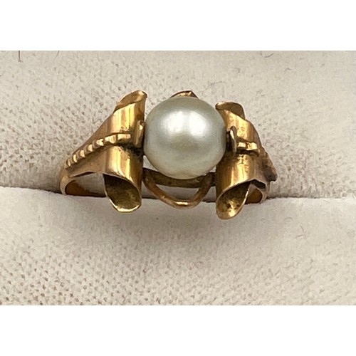 412 - A single cultured pearl ring set in yellow metal which tests as approximately 14 carat gold. Size N.... 