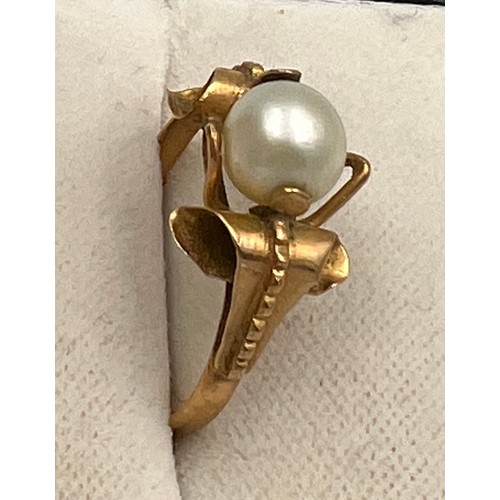 412 - A single cultured pearl ring set in yellow metal which tests as approximately 14 carat gold. Size N.... 