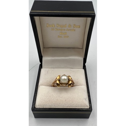 412 - A single cultured pearl ring set in yellow metal which tests as approximately 14 carat gold. Size N.... 