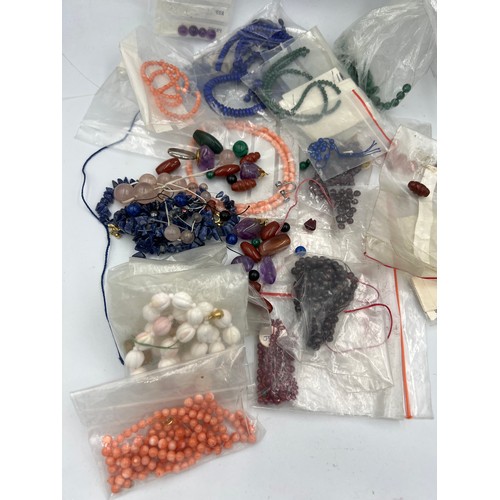 385 - A quantity of beads to include coral, rubies, amethyst, malachite, lapis etc. Some mounted, many loo... 