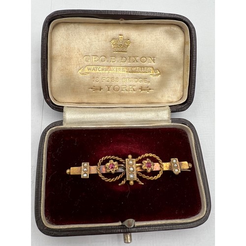 387 - A 15 carat gold bar brooch set with seed pearls and pink stones in original silk and velvet lined pr... 