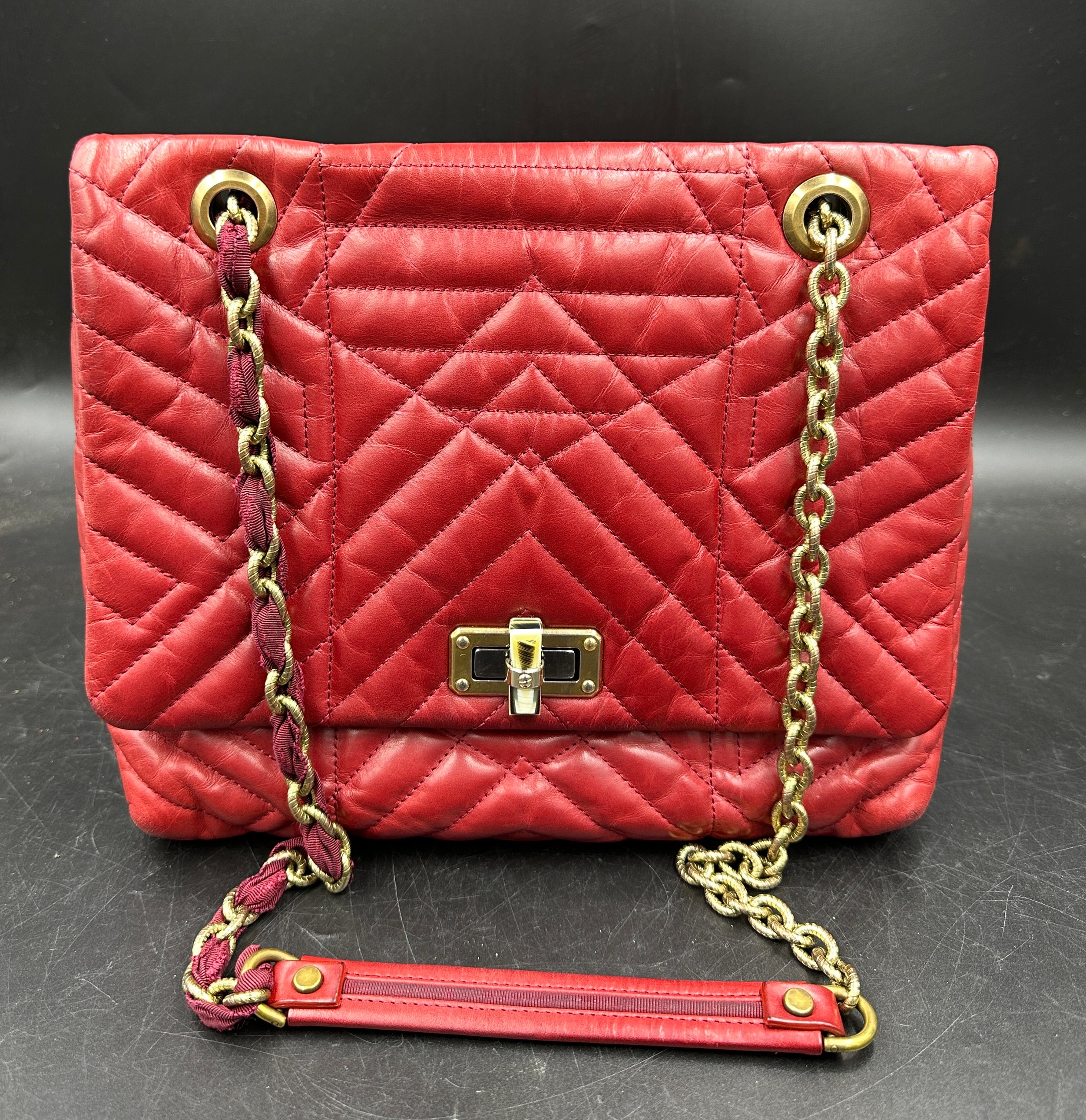 A red leather Lanvin quilted handbag with brass coloured chain fabric and leather strap clasp to f