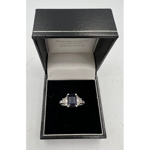 329 - An emerald cut sapphire and baguette diamond ring, set in platinum. Size L. Weight 5gm.