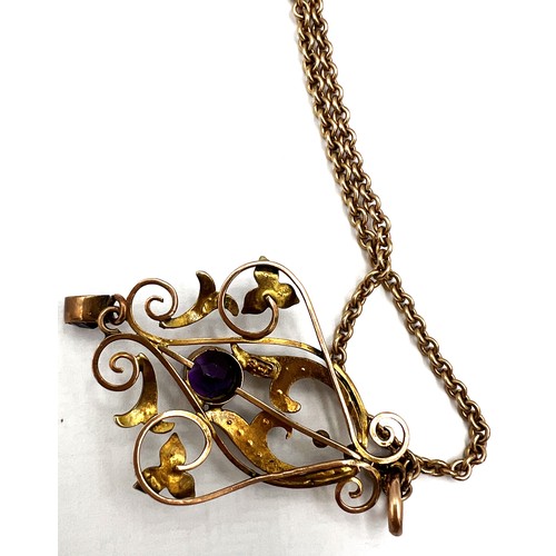 386 - An Edwardian 9 carat gold pendant set with amethyst and seed pearls suspended on an unmarked yellow ... 