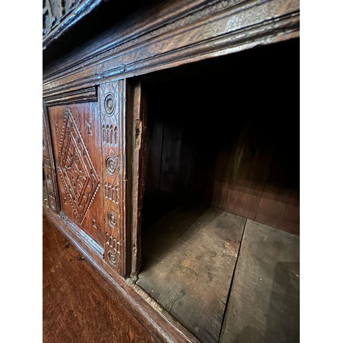 42 - An oak court cupboard with carving to the top, MA 1698. 138cm w x 57cm d x 151cm h.
Top shows signif... 