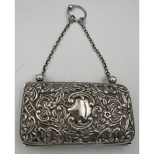 918 - A hallmarked silver purse with chain and finger ring with repoussé decoration and vacant cartouche. ... 