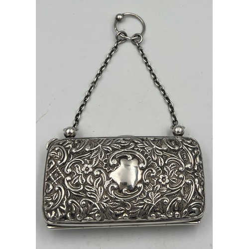 918 - A hallmarked silver purse with chain and finger ring with repoussé decoration and vacant cartouche. ... 