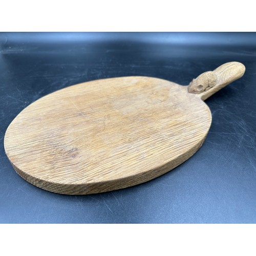 79 - Robert Thompson 'Mouseman' of Kilburn, an adzed oak cheese board of oval form with a carved mouse si... 