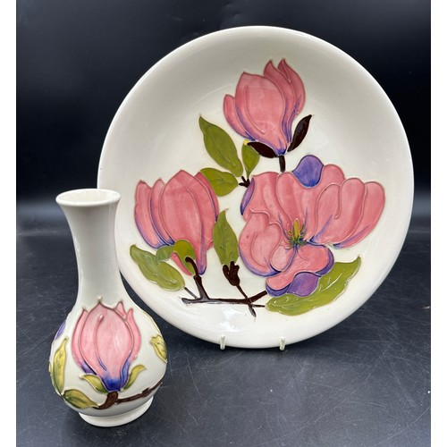 258 - Two Moorcroft ceramics in the Magnolia pattern, a plate approx 26cm d and a bud vase approx 15.5cm h... 