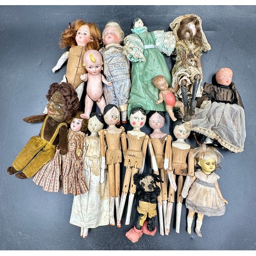 1124 - A collection of small dolls to include seven folk art style wooden peg dolls, 15cm l, six with bisqu... 