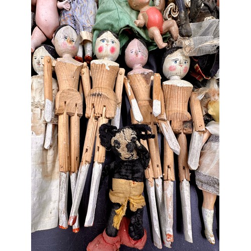 1124 - A collection of small dolls to include seven folk art style wooden peg dolls, 15cm l, six with bisqu... 