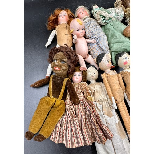 1124 - A collection of small dolls to include seven folk art style wooden peg dolls, 15cm l, six with bisqu... 