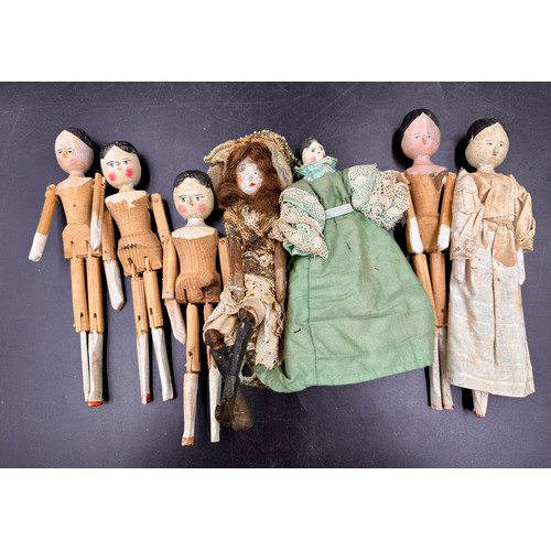 1124 - A collection of small dolls to include seven folk art style wooden peg dolls, 15cm l, six with bisqu... 