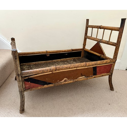 1128 - A 19thC lacquered bamboo doll's bed. 51cm h x 72cm at widest point.