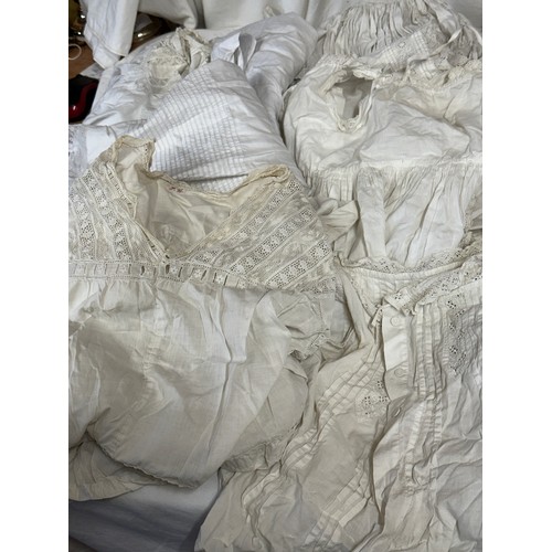 720 - Late 19thC/early 20thC linens to include 14 christening gowns, a camisole, nightdress and silk cream... 